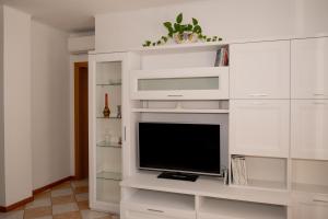 Terrace Apartment -M3 Apartments في ليدو دي يسولو: غرفة معيشة مع تلفزيون ورفوف بيضاء +18 صورة