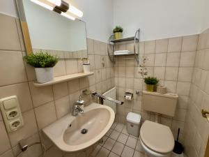 a bathroom with a sink and a toilet at Gästehaus Vogel - Silbermöwe in Horumersiel +12 photos