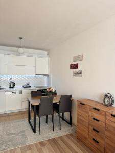 a kitchen with a table and chairs in a room at AR Apartment in Kosovo Polje