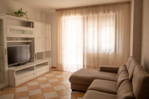 Terrace Apartment -M3 Apartments في ليدو دي يسولو: غرفة معيشة مع أريكة وتلفزيون
