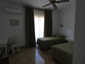 A bed or beds in a room at Hostal Port Fornells