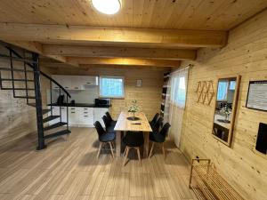 a dining room and kitchen in a tiny house at Letni Vibe -wynajem domków letniskowych in Skulsk