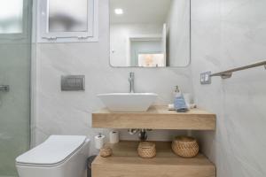 łazienka z umywalką, toaletą i lustrem w obiekcie Beautiful Bungalow Maspalomas Lago w mieście Maspalomas +19 zdjęć