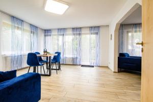 a living room with a table and blue chairs at Hotel Garni Jägerhof in Sigmaringen