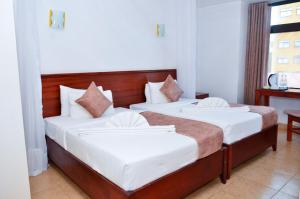 Ein Bett oder Betten in einem Zimmer der Unterkunft The Kyaka Hotel