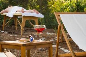 a person laying in a bed with a glass of wine at VIScovery Boutique in Rukavac