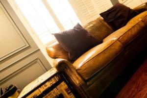 a brown leather couch in a room with a window at 朵兒dor韓國汗蒸幕 동대문점 商務旅店 in Taipei