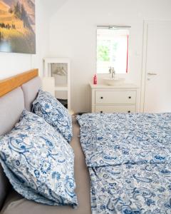 a bedroom with a bed with blue and white sheets and a sink at Home of heart Schladming in Schladming +43 photos