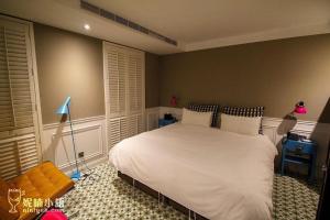 a bedroom with a white bed and a blue lamp at 朵兒dor韓國汗蒸幕 동대문점 商務旅店 in Taipei