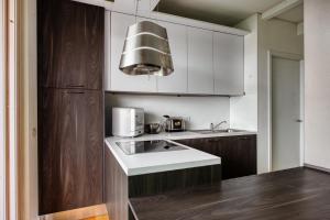 a kitchen with a sink and a microwave at GiaxTower Gym Spa & Pool Bright Space 6' piano in Milan +19 photos