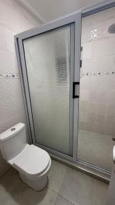 a bathroom with a toilet and a glass shower at 3 Bedroom House In Oyarifa - Accra in Trofwi