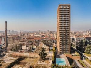 a tall building with a pool in front of a city at GiaxTower Gym Spa & Pool Bright Space in Milan