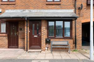 a bench sitting in front of a brick building at Parkland House by Grandeur Property in Poole