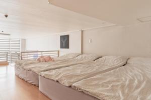 un grande letto con un animale di peluche sopra di House with Park View a Bucheon