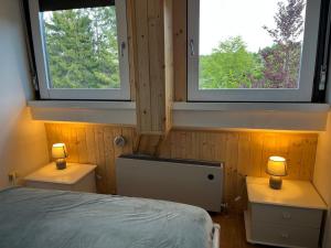 a bedroom with two windows and a bed at Piancavallo Loft - Garage & View in Piancavallo