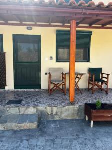 a patio with two chairs and a table and a door at Monolithos in Város