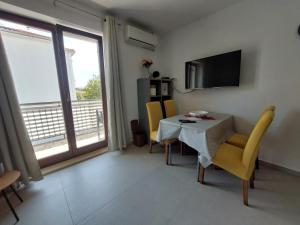 マリンスカにあるApartment Josipaのテーブルと椅子とテレビのあるダイニングルーム