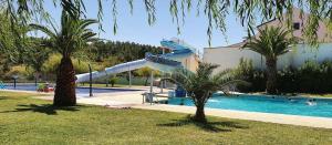 a swimming pool with a slide in a resort at Sofiamarholidays O Cantinho da Avó Bina in Moita