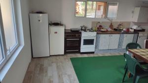 una cucina con elettrodomestici bianchi e un tappeto verde di Soba Soko a Soko Banja