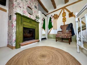 a living room with a fireplace and a chair at El RINCÓN DE LAS PARRAS in Las Parras de Martín
