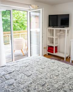 a bedroom with a bed and a tv and a balcony at Home of heart Schladming in Schladming
