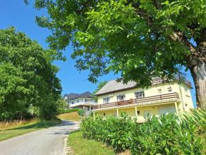 a large yellow house on a road at Pohorje Retreat II in Poljčane