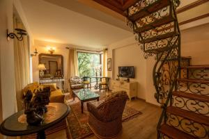 a living room with a table and a spiral staircase at Lake View 2BHK close to mall road l Lake Daze in Nainital