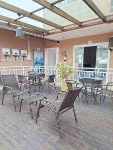 a deck with tables and chairs on a patio at Coração Do Oceano Village in Penha