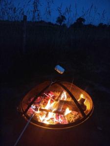 a fire pit in the middle of a field at night at Lodge romantique "esprit brocante" et son jacuzzi privatif in Lapalisse