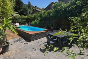 une cour avec une piscine, une table et des chaises dans l'établissement Maison de rue avec piscine, à La Celle-sous-Gouzon