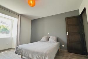 une chambre avec un lit et une porte en bois dans l'établissement Maison de rue avec piscine, à La Celle-sous-Gouzon