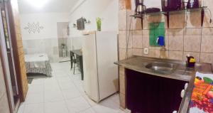 a kitchen with a sink and a refrigerator at Casa COP Maria bonita in Belém +4 photos