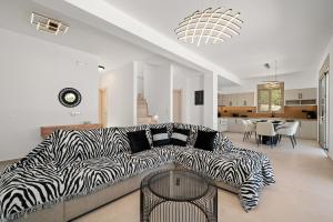 een woonkamer met een bank met zebraprint en een tafel bij Villa Callistemon in Pitsidia
