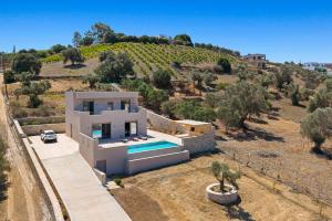 een villa met een zwembad op een heuvel bij Villa Callistemon in Pitsidia