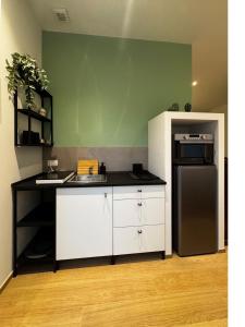 a kitchen with white cabinets and a black refrigerator at Appartamento Bianca in Prato