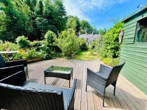 un patio con due sedie e un tavolo e un edificio verde di Quarry Cottage - Snug Hideaway a Box