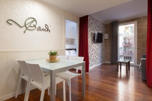 a dining room with a white table and white chairs at Enjoybcn Gaudi Apartments in Barcelona