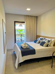 a bedroom with a large bed with towels on it at Village Completo na Vila de Praia do Forte in Mata de Sao Joao