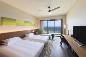 a hotel room with two beds and a flat screen tv at Hyatt Regency Seragaki Island Okinawa in Onna