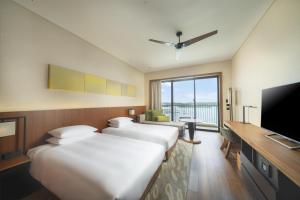a hotel room with two beds and a flat screen tv at Hyatt Regency Seragaki Island Okinawa in Onna