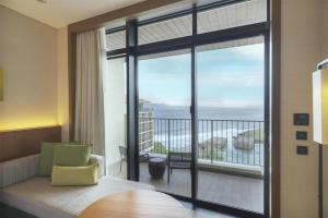 a room with a large window with a view of the ocean at Hyatt Regency Seragaki Island Okinawa in Onna