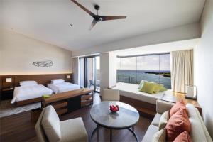 a hotel room with a bed and a living room at Hyatt Regency Seragaki Island Okinawa in Onna