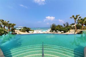 a swimming pool with the ocean in the background at Hyatt Regency Seragaki Island Okinawa in Onna