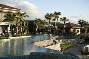 a pool at a resort with palm trees at Hyatt Regency Seragaki Island Okinawa in Onna