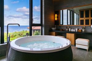a bath tub in a bathroom with a view of the ocean at Hyatt Regency Seragaki Island Okinawa in Onna
