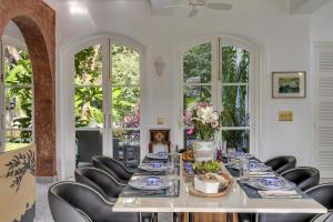 a dining room with a long table and chairs at La Pasado, Huge 4 BHK villa with Large Private Pool & Garden, in Assagao, Complimentary Breakfast, full time caretaker, Bathtub, ideal for large groups in Assagao +99 photos