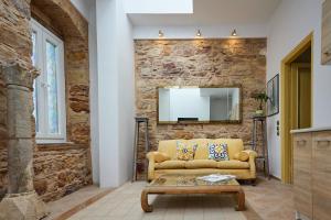 a living room with a couch and a stone wall at Kampos Mansion 1 in Chios +46 photos