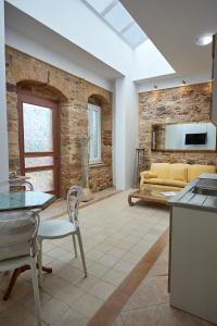a kitchen and living room with a stone wall at Kampos Mansion 1 in Chios