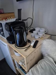 a wooden table with a coffee maker and cups on it at Chambre meublé Eden à Noves in Noves