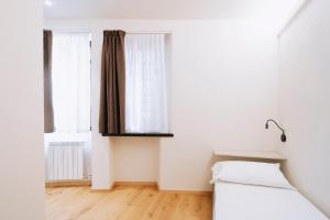 a white room with a bed and two windows at Aosta Holiday - Pam Pam in Aosta